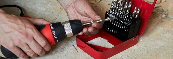 Person setzt Bohrer in Akkuschrauber ein